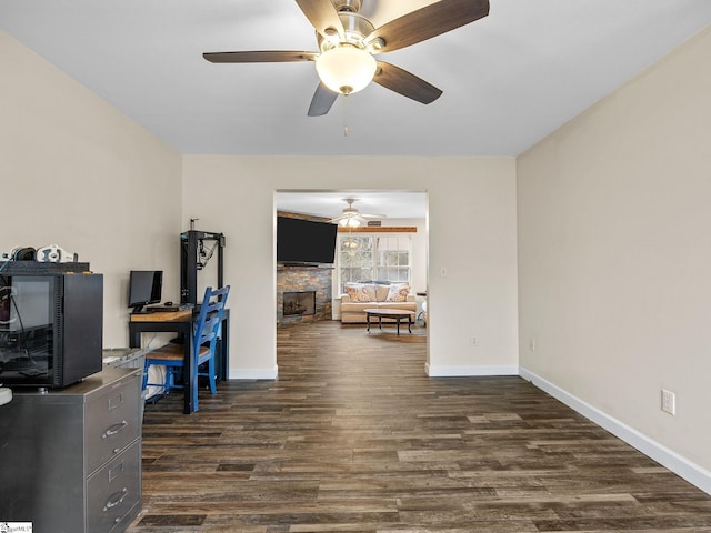 office area with dark wood-type flooring and a fireplace