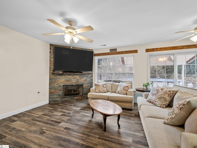 living room with a healthy amount of sunlight, a fireplace, dark hardwood / wood-style floors, and ceiling fan