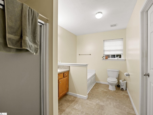 bathroom featuring vanity, a washtub, and toilet