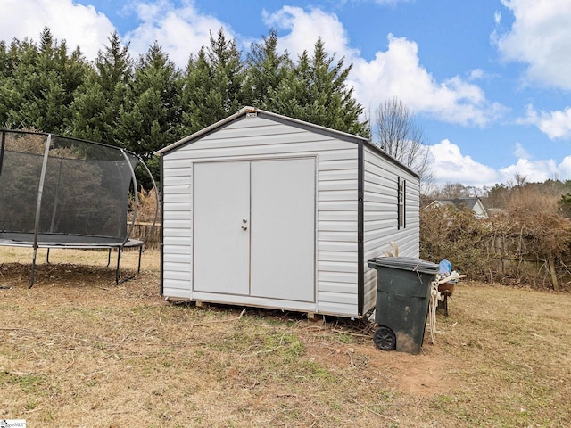 view of outbuilding with a yard and a trampoline