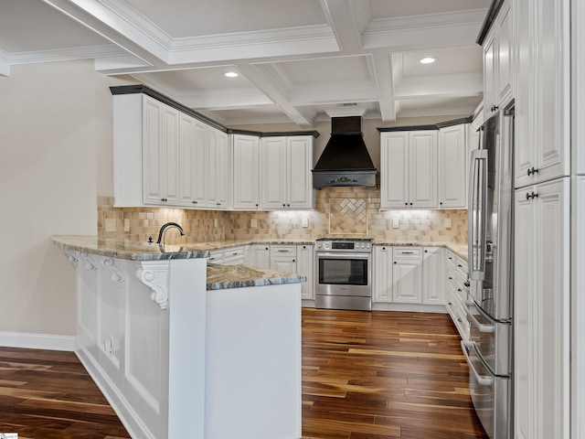 kitchen with beam ceiling, dark wood finished floors, custom range hood, appliances with stainless steel finishes, and a peninsula