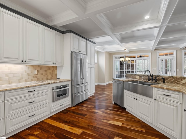 kitchen with tasteful backsplash, appliances with stainless steel finishes, dark wood-style flooring, beamed ceiling, and a sink