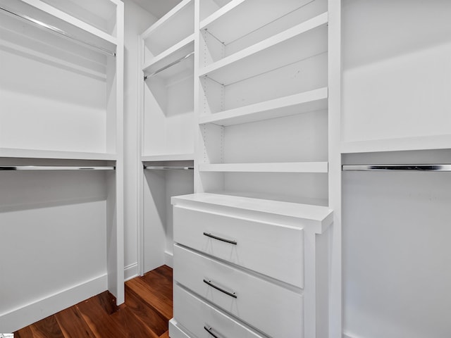 walk in closet with dark wood-style flooring