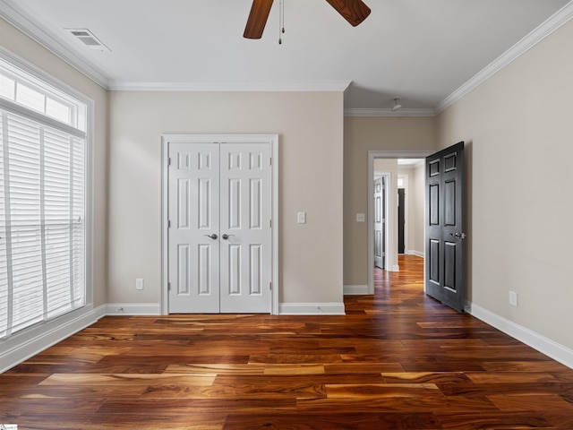 unfurnished bedroom featuring ornamental molding, visible vents, baseboards, and wood finished floors