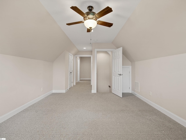 bonus room with light colored carpet, vaulted ceiling, visible vents, and baseboards