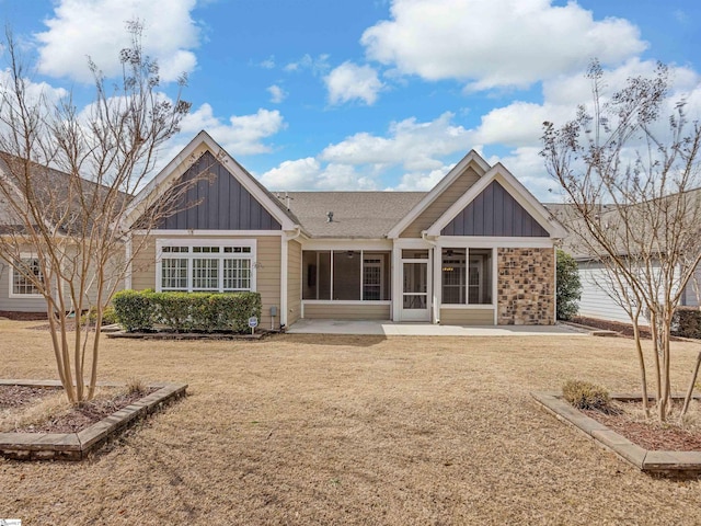 rear view of property with board and batten siding, a patio, and a lawn