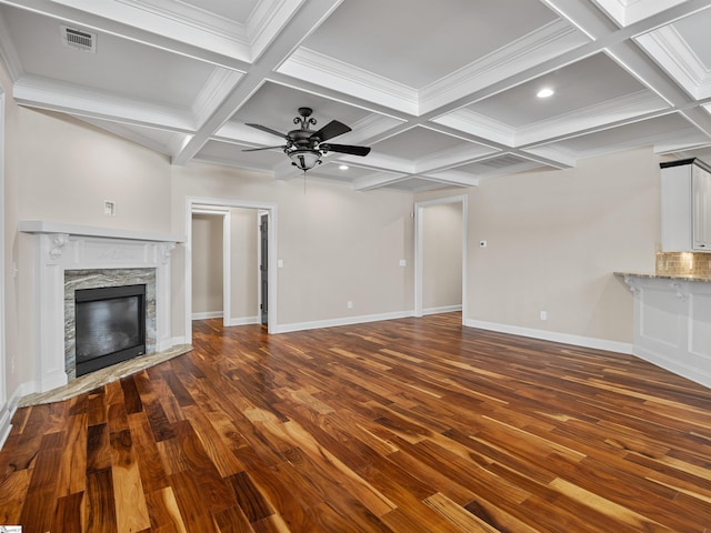 unfurnished living room featuring baseboards, visible vents, wood finished floors, and a stone fireplace