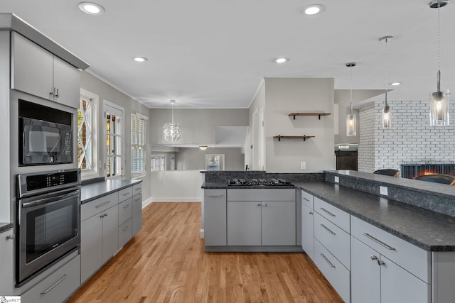 kitchen featuring gray cabinets, light wood-type flooring, hanging light fixtures, and black appliances