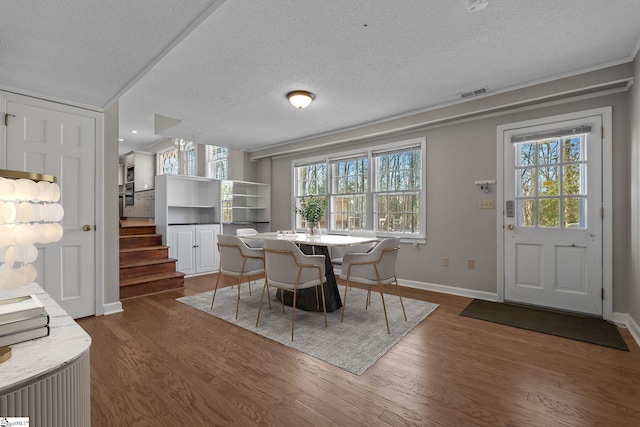 dining area with dark hardwood / wood-style flooring and a textured ceiling