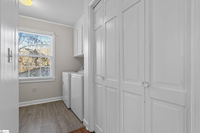 washroom with cabinets, crown molding, separate washer and dryer, and light hardwood / wood-style floors