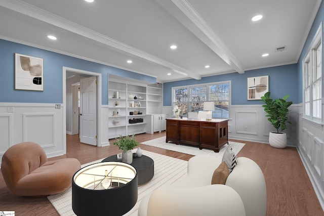 interior space with ornamental molding, beam ceiling, and light hardwood / wood-style flooring