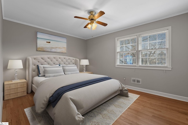 bedroom with hardwood / wood-style floors, ornamental molding, and ceiling fan