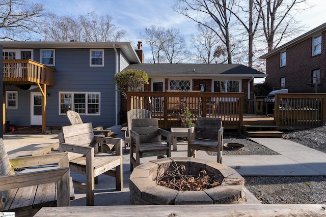 rear view of property with a patio area, a deck, and a fire pit