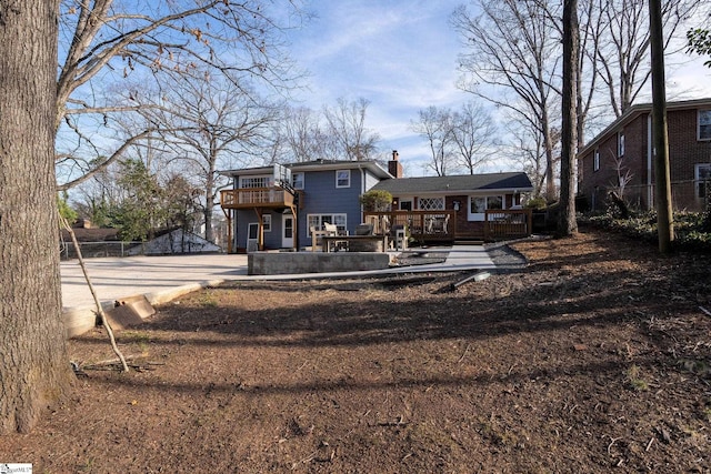 rear view of property featuring a wooden deck