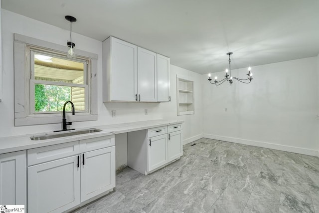 kitchen featuring hanging light fixtures, white cabinetry, sink, and an inviting chandelier