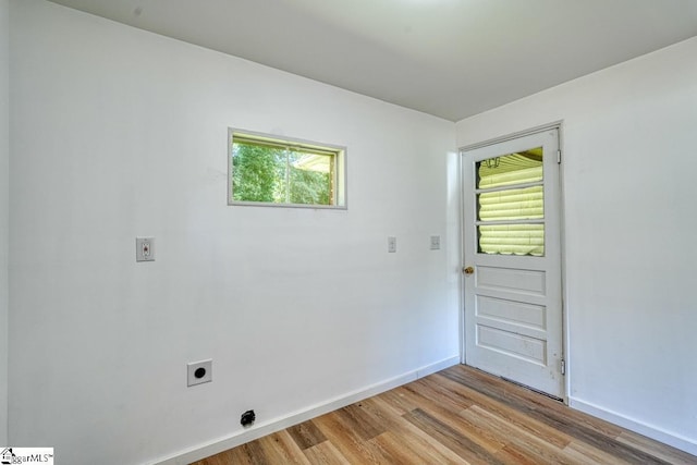 laundry room featuring a healthy amount of sunlight, hookup for an electric dryer, and light wood-type flooring