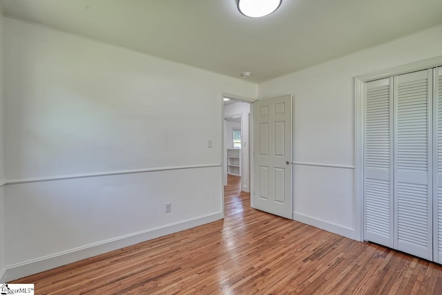 unfurnished bedroom featuring hardwood / wood-style floors and a closet