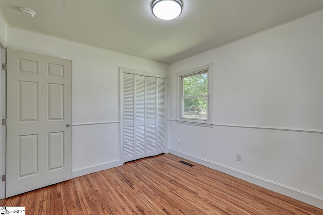 unfurnished bedroom with a closet and light wood-type flooring