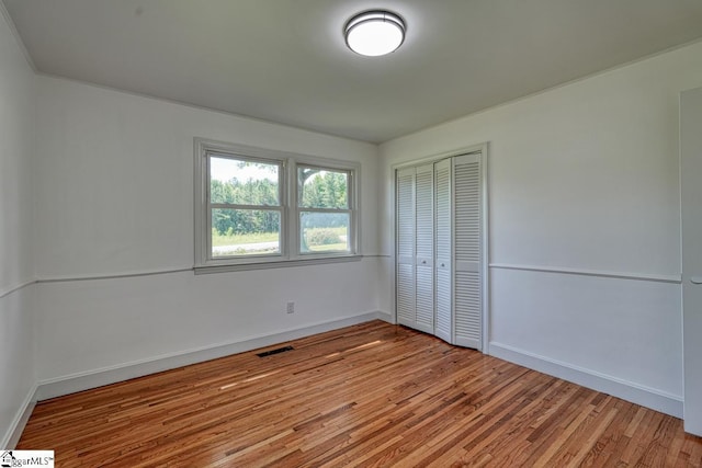 unfurnished bedroom featuring a closet and light wood-type flooring