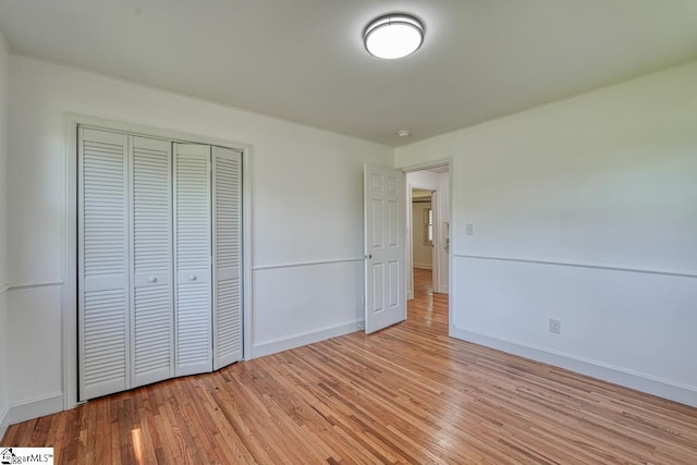 unfurnished bedroom featuring light hardwood / wood-style floors and a closet