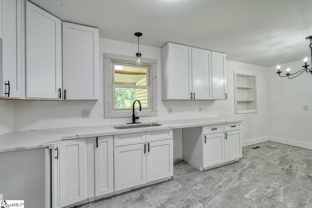 kitchen with sink, pendant lighting, and white cabinets