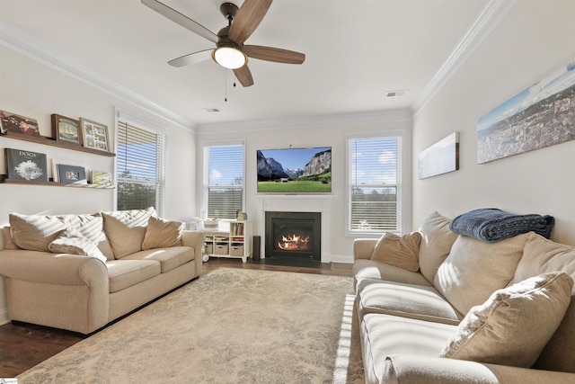 living room with dark wood-type flooring, ornamental molding, and ceiling fan