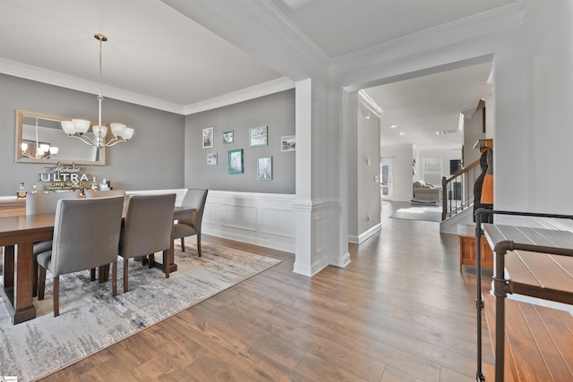 dining room with an inviting chandelier, hardwood / wood-style flooring, and ornamental molding