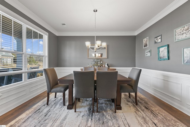 dining space featuring crown molding, a chandelier, and dark hardwood / wood-style flooring