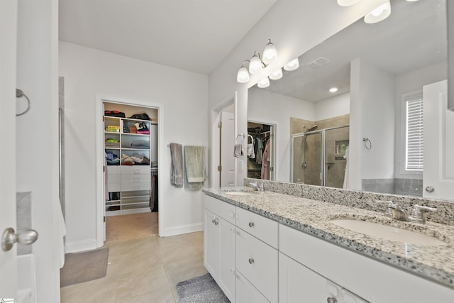 bathroom with tile patterned flooring, vanity, and a shower with shower door