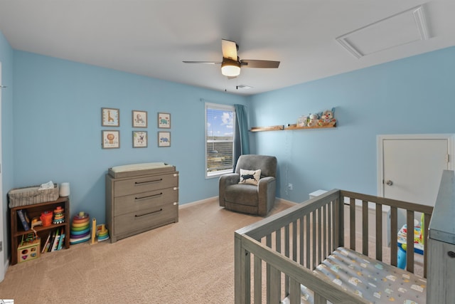 bedroom with light carpet, a nursery area, and ceiling fan