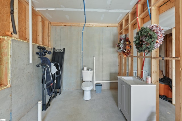 bathroom featuring vanity, concrete flooring, and toilet