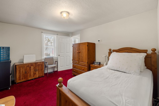 bedroom featuring a textured ceiling and dark carpet