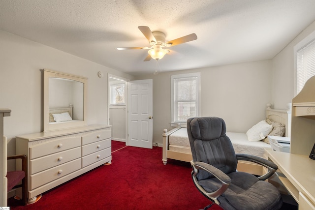 carpeted office space featuring ceiling fan and a textured ceiling