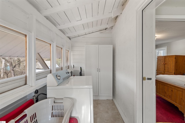 clothes washing area with wood ceiling and separate washer and dryer