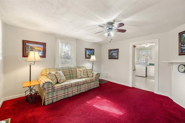 living room featuring washer / clothes dryer, ceiling fan, a textured ceiling, and carpet flooring