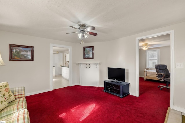 living room featuring ceiling fan, a textured ceiling, and carpet flooring