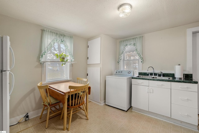 clothes washing area with washer / dryer, sink, and a textured ceiling