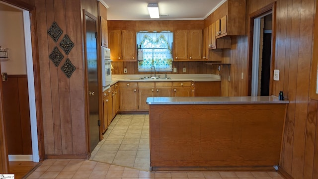 kitchen featuring wooden walls, kitchen peninsula, sink, and white oven