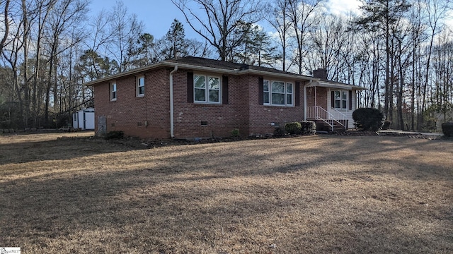 view of front of house featuring a storage shed and a front yard