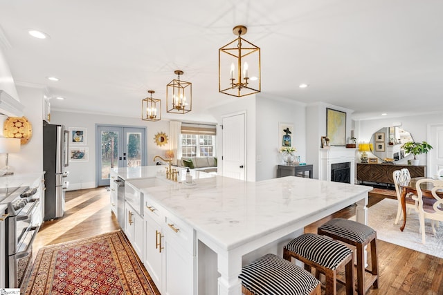 kitchen featuring a large island, hanging light fixtures, french doors, and appliances with stainless steel finishes