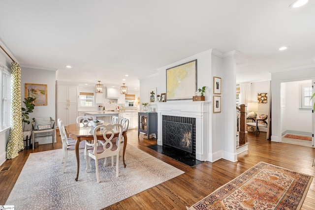 dining area featuring ornamental molding and dark wood-type flooring