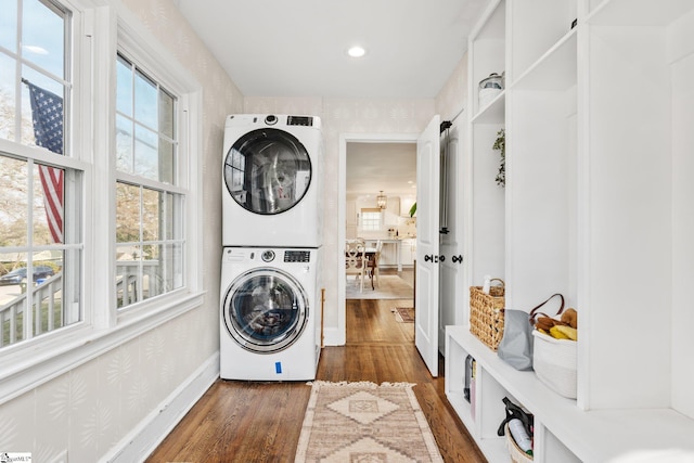 washroom with stacked washer / drying machine and dark hardwood / wood-style floors