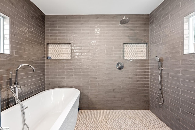 bathroom with tile patterned flooring, shower with separate bathtub, a healthy amount of sunlight, and tile walls