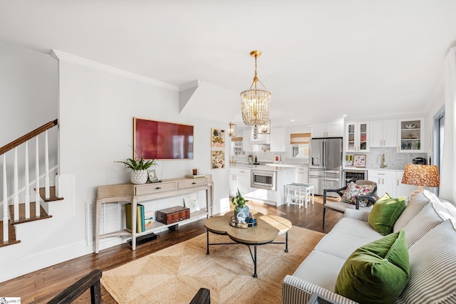 living room featuring crown molding, beverage cooler, hardwood / wood-style floors, and a notable chandelier