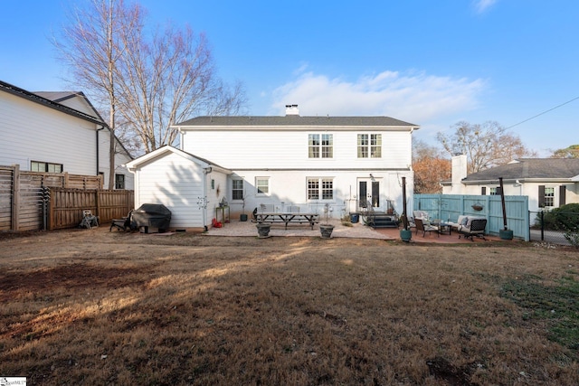 back of property with a lawn and a patio area