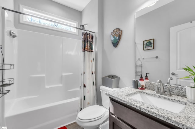 full bathroom with vanity, shower / bath combo, and toilet