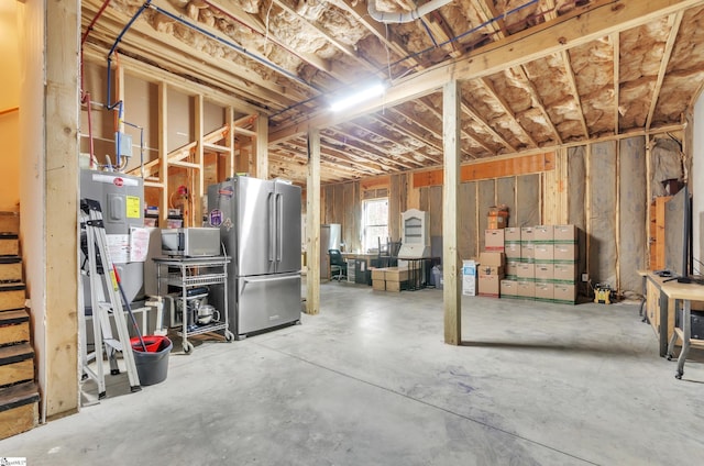 basement featuring water heater and stainless steel fridge