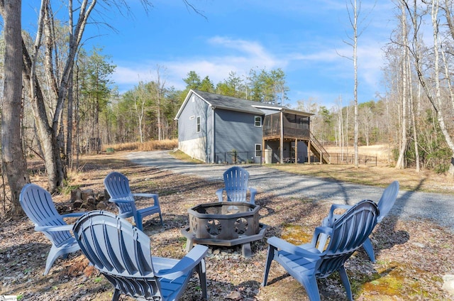 view of yard featuring a sunroom and a fire pit