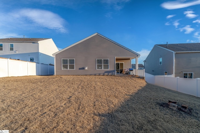 rear view of house featuring a lawn