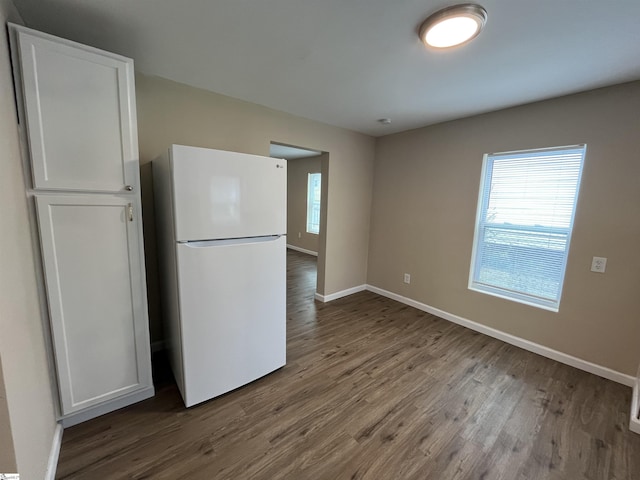 kitchen with white refrigerator, white cabinetry, and hardwood / wood-style floors